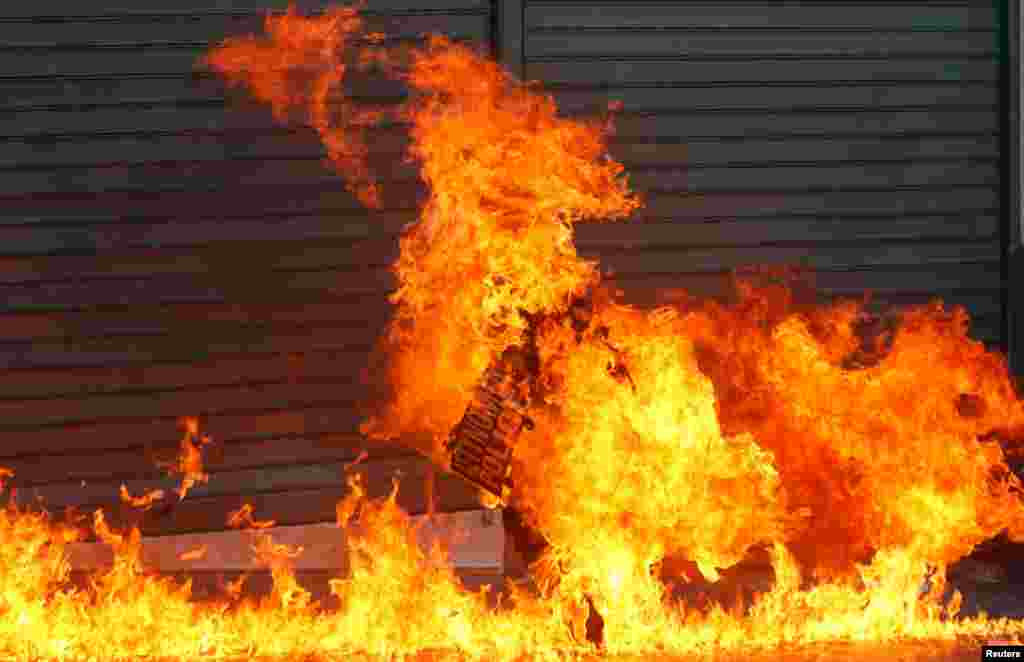 A riot policeman is engulfed by flames after a protester threw petrol bombs in Athens' Syntagma square, Sept. 26, 2012.