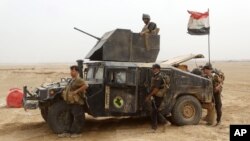 Military reinforcements for Iraqi anti-terrorism forces arrive at the Ramadi Stadium after regaining control of the complex and the neighboring al-Bugleeb area, Oct. 6, 2015.