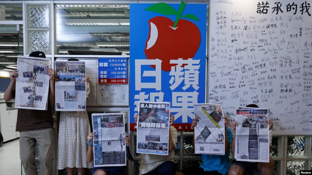 Para anggota staf koran independen Hong Kong, Apple Daily dan penerbitnya, Next Digital, berfoto dengan edisi terakhir koran itu di kantor pusatnya, di Hong Kong, China, 24 Juni 2021. (Foto: Tyrone Siu/Reuters)