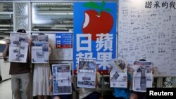 Para anggota staf koran independen Hong Kong, Apple Daily dan penerbitnya, Next Digital, berfoto dengan edisi terakhir koran itu di kantor pusatnya, di Hong Kong, China, 24 Juni 2021. (Foto: Tyrone Siu/Reuters)