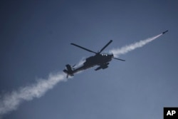 An Israeli Apache helicopter fires a missile towards southern Lebanon as seen from northern Israel, Oct. 13, 2024.