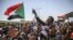 Sudanese protesters wave national flags as they chant slogans during a sit-in outside the army headquarters in the capital Khartoum, April 26, 2019.