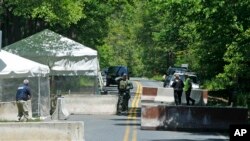 FILE - Security officials stand at a checkpoint outside of Camp Round Meadow, on the closed road leading up to the presidential retreat of Camp David, in Thurmont, Maryland, May 18, 2012. 