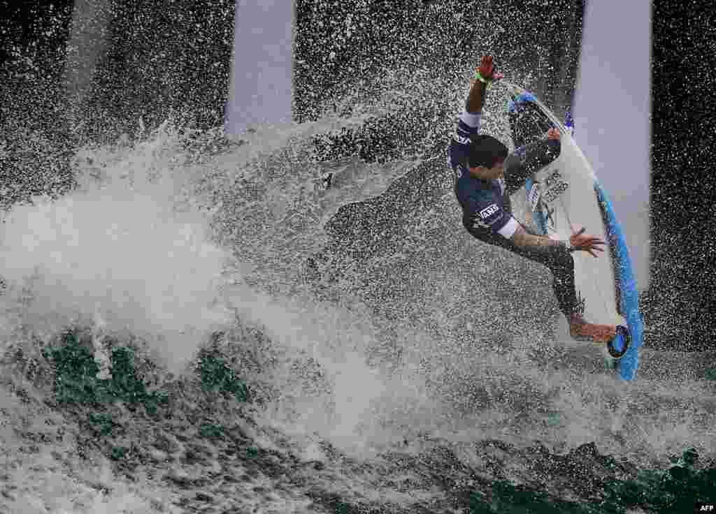Alex Ribeiro of Brazil competes beside the pier during round four of the Vans US Open of Surfing, held at iconic Huntington Beach, California.