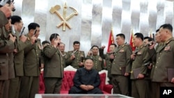 North Korean leader Kim Jong Un, sitting center, is surrounded by senior military officials holding “Paektusan” commemorative pistols they received from him during a ceremony in Pyongyang, July 26, 2020. (Photo released by the North Korean government)