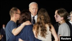 El presidente Joe Biden habla con la periodista ruso-estadounidense Alsu Kurmasheva, quien fue liberada de su detención en Rusia, junto a sus hijas Bibi y Miriam Butorin y su esposo Pavel Butorin, en la Base Conjunta Andrews en Maryland, EEUU, el 1 de agosto de 2024. 