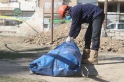 A member of The First Responders team in Raqqa seals a bag containing a body recovered from a mass graves. The exhuming operation use primitive means, as the team lacks technology to analyze the remains. (Photo: Osama al-Khalaf)
