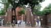 FILE - In this Aug. 13, 2019, file photo, pedestrians walk through the gates of Harvard Yard at Harvard University in Cambridge, Mass. Harvard and the Massachusetts Institute of Technology filed a federal lawsuit Wednesday, July 8, 2020, challenging the T