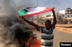 A protester waves a flag during what the information ministry calls a military coup in Khartoum, Sudan, October 25, 2021.