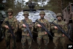 Tentara Bundeswehr Jerman menunggu untuk menyambut Kanselir Jerman Olaf Scholz saat kedatangannya di Lapangan Latihan di Pabrade, sekitar 60 kilometer di utara ibu kota Vilnius, Lithuania, Senin, 6 Mei 2024. (Mindaugas Kulbis/AP)