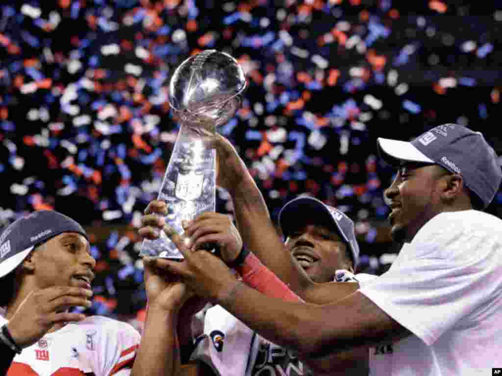 New York Giants players including wide receiver Victor Cruz, left, and wide receiver Hakeem Nicks, right, celebrate their team's 21-17 win over the New England Patriots in the NFL Super Bowl XLVI football game February 5, 2012, in Indianapolis, Indiana.