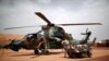 Des soldats français inspectent un hélicoptère d'attaque Tiger au camp opérationnel de la plateforme du désert (PfOD) lors de l'opération Barkhane à Gao, au Mali, le 1er août 2019.