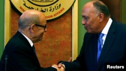 French Foreign Minister Jean-Yves Le Drian shakes hands with Egyptian Foreign Minister Sameh Shoukry (R) after their joint news conference in Cairo, Egypt, June 8, 2017. 
