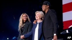 លោក​ស្រី Hillary Clinton បេក្ខជន​ពី​គណបក្ស​ប្រជាធិបតេយ្យ​ នៅ​លើ​វេទិកា​ជាមួយ​តាសម្តែង Jay Z ​(ស្តាំ) និង​នាង​ Beyonce នៅ​ក្នុង​ពេល​ប្រគំ​តន្ត្រី​មួយ​នៅ​មជ្ឈមណ្ឌល​ Wolstein រដ្ឋ Ohio កាល​ពី​ថ្ងៃ​សុក្រ។