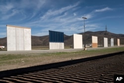 FILE - Border wall prototypes stand in San Diego near the Mexico U.S. border, seen from Tijuana, Dec. 22, 2018.