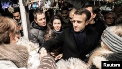 French President Emmanuel Macron shakes hands with visitors of the Christmas market in Strasbourg, France, Dec. 14, 2018. 