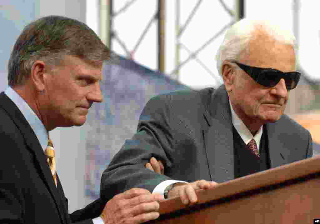Evangelist Billy Graham, right, is assisted by his son Franklin before delivering a sermon during the Metro Maryland Festival,July 9, 2006, in Baltimore.