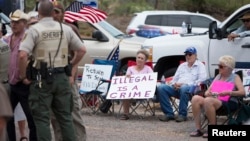 FILE - Thelma and Don Christie, center, of Tucson demonstrate against the arrival of undocumented immigrants in Oracle, Arizona, July 15, 2014.