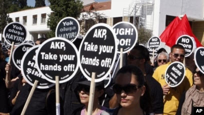 Protesters in Nicosia holding British Bases Out banners