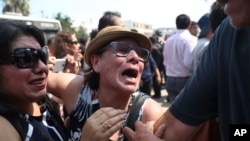 Supporters of former Peruvian President Alan Garcia cry as they learn that the former leader died from a self-inflicted gun shot, outside the hospital where he was taken after he shot himself, in Lima, Peru, April 17, 2019. 