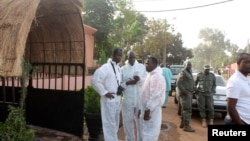 Health officials stand outside La Terrasse restaurant where militants killed five people, including a French citizen and a Belgian citizen, in a gun attack in Bamako, March 7, 2015. 