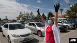 Una mujer eleva una oración en un culto cristiano al aire libre en un estacionamiento público en Las Vegas, Nevada, ante el avance de la pandemia en Estados Unidos, el domingo 12 de abril de 2020.