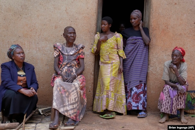 Prudencienne Namukobwa, 85, second left, sits with her guests outside her house in Ngozi, Burundi, Friday, Sept. 20, 2024. (AP Photo/Brian Inganga)