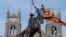 Crews attach straps to the statue of Confederate General J.E.B. Stuart on Monument Avenue in Richmond, Va., July 7, 2020.