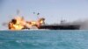 In this picture released by the Iranian Tasnim news agency on Feb. 25, 2015, a replica of a U.S. aircraft carrier is exploded by the Revolutionary Guard's speedboats during large-scale naval drills near the entrance of the Persian Gulf, Iran.