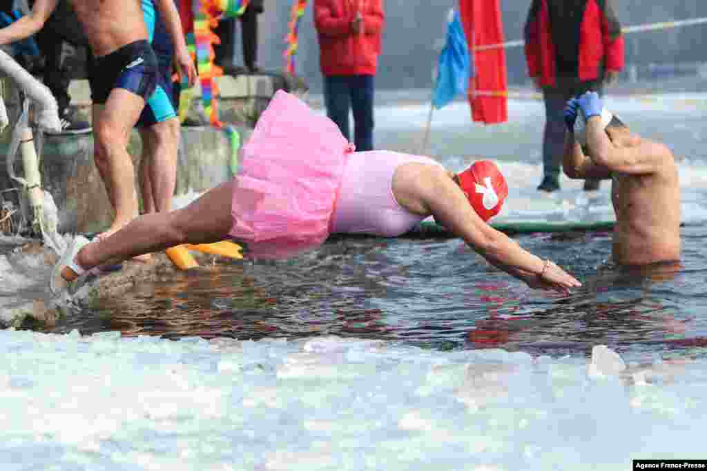 A winter swimming enthusiast dives into a partly frozen lake in Shenyang, in northeastern China&#39;s Liaoning province.