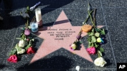 An impromptu memorial created on a blank Hollywood Walk of Fame star by fans of the late actress and author Carrie Fisher, who does not have an official star on the world-famous promenade, is seen in Los Angeles, Dec. 28, 2016. Paste-on letters spell out her name and the phrase "May the force be with you always. Hope."