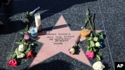 An impromptu memorial created on a blank Hollywood Walk of Fame star by fans of the late actress and author Carrie Fisher, who does not have an official star on the world-famous promenade, is seen in Los Angeles, Dec. 28, 2016.