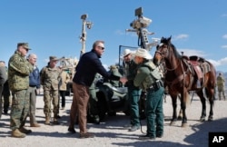 Acting Secretary of Defense Patrick Shanahan, center, greets Border Patrol Agents Carlos Lerma, second from right, Moises Gonzalez, right, and the horse they use for patrols during a tour of the U.S.-Mexico border at Santa Teresa Station in Sunland Park, N.M.
