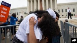 Jackelin Alfaro, 7, of Washington hugs her aunt Gelin Alfaro, of Veracruz, Mexico, during an immigration rally at the Supreme Court in Washington, June 23, 2016.