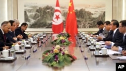 China's Foreign Minister Wang Yi, second from right, speaks as Tunisia's Foreign Minister Khemaies Jhinaoui, second from left, listens during a meeting at the Ministry of Foreign Affairs in Beijing, July 19, 2017.