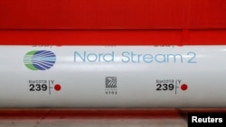 ເຄື່ອງໝາຍສັນຍາລັກຂອງໂຄງການທໍ່ແກັສ Nord Stream 2 ແມ່ນເຫັນໄດ້ຢູ່ວົງລ້ອມຂອງທໍ່ຂະໜາດໃຫຍ່ ຢູ່ທີ່ ໂຮງງານຜະລີດທໍ່ (Chelyabinsk Pipe Rolling Plant) ທີ່ ບໍລິສັດກຸ່ມ ChelPipe ເປັນເຈົ້າຂອງ ໃນເມືອງ Chelyabinsk ຂອງຣັດເຊຍ, ວັນທີ 26 ກຸມພາ 2020.