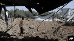 အစ္စရေးဘက်က ပစ်လိုက်တဲ့ ဒုံးကျည်ထိမှန်ပျက်စီးသွားတဲ့ အိမ်ကို လှည့်လည်ကြည့်ရှုနေတဲ့ ပါလက်စတိုင်းသားတစ်ဦး။ (ဂျူလိုင် ၆၊ ၂၀၁၄)