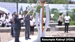 Le président rwandais Paul Kagame, accompagné par son homologue tanzanien Dr John Magufuli, allument au mémorial de Gisozi à Kigali, une flamme qui brûlera durant les cents jours de commémoration du 22e anniversaire du génocide au Rwanda, 7 avril 2016. 