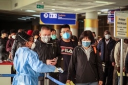 FILE - Passengers arriving on a China Southern Airlines flight from Changsha in China are screened upon their arrival at the Jomo Kenyatta international airport in Nairobi, Kenya, Jan. 29, 2020.