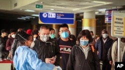 FILE - Passengers arriving on a China Southern Airlines flight from Changsha in China are screened for the new type of coronavirus upon their arrival at the Jomo Kenyatta international airport, in Nairobi, Kenya, Jan. 29, 2020.