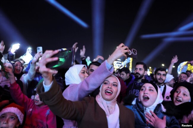 Warga Suriah yang kini menikmati kebebasan, berkumpul selama perayaan Tahun Baru, pasca tergulingnya Bashar al-Assad dari Suriah, di Damaskus, Suriah, 1 Januari 2024.