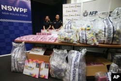 FILE - Australia Methylamphetamine: Officers stand by a display of confiscated drugs in Sydney, Monday, Jan. 15, 2016.