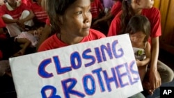 A Cambodian sex worker, center, holds a banner read "Closing Brothels" in a conference room in Phnom Penh, file photo. 