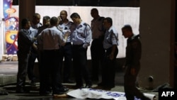 FILE - Israeli policemen stand next to the body of a suspected Palestinian attacker, who opened fire on people at a bus station in the southern Israeli city of Beersheba, Oct. 19, 2015.