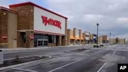 An empty parking lot is seen as retail stores are closed April 15, 2020, in Whitestown, Indiana. Evidence of the devastating impact of the coronavirus on the U.S. economy has been steadily emerging. 