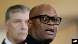 Dallas police chief David Brown, front, and Dallas mayor Mike Rawlings, rear, talk with the media during a news conference, July 8, 2016, in Dallas. 