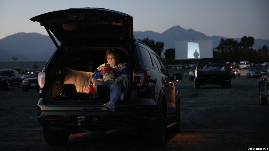Serena Benavidez looks at her smartphone while waiting for a movie to start at Mission Tiki drive-in theater in Montclair, Calif., on May 28, 2020. (AP Photo/Jae C. Hong, file)