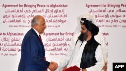 Zalmay Khalilzad, representante especial dos EUA para a reconciliação Afeganistão (esq) e Mullah Abdul Ghani Baradar, co-fundador do Talibã