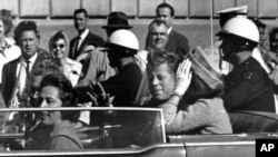 El presidente John F. Kennedy en una caravana junto a la primera dama Jacqueline Kennedy, momentos antes de ser asesinado en Dallas.