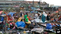 Warga menyelamatkan sisa-sisa rumah mereka yang rusak akibat Topan Rai di Kota Cebu, Filipina tengah pada 17 Desember 2021. (Foto: AP)